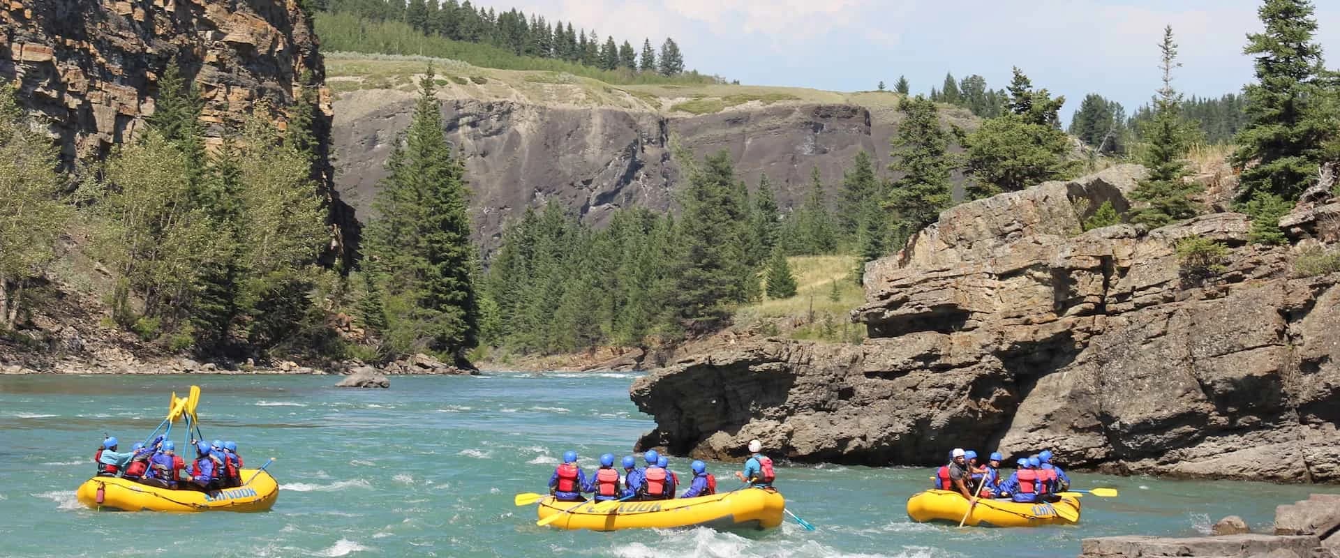 Yellow Chinook rafts on the Bow River in Horseshoe Canyon under a blue sky