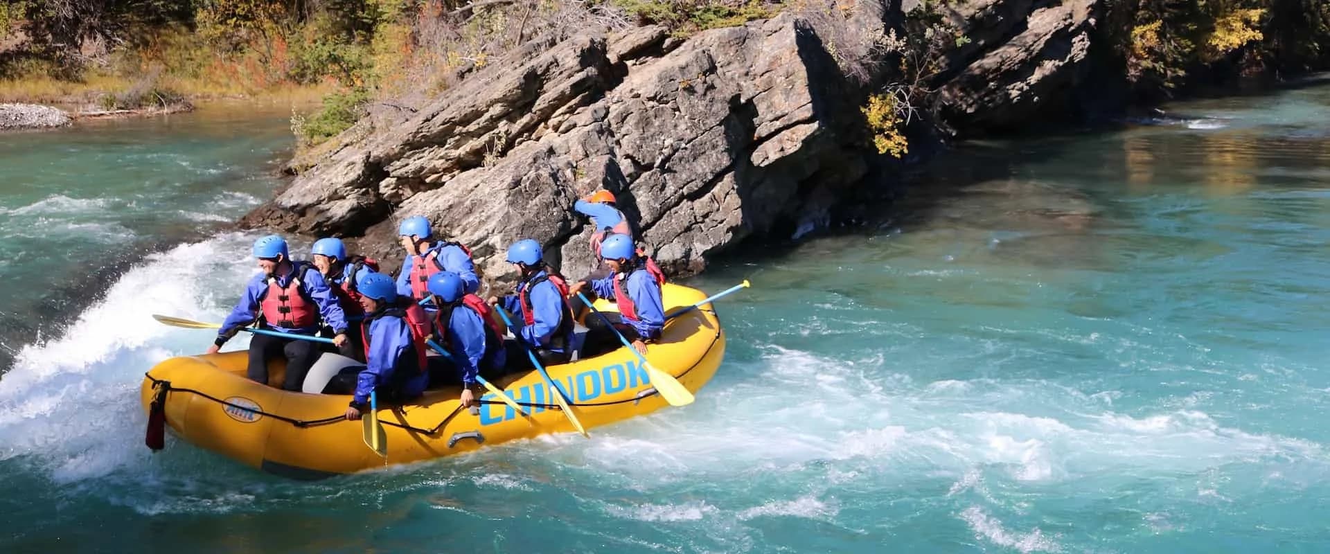 Family in a Chinook raft splashing through a rapid on the Kananaskis River